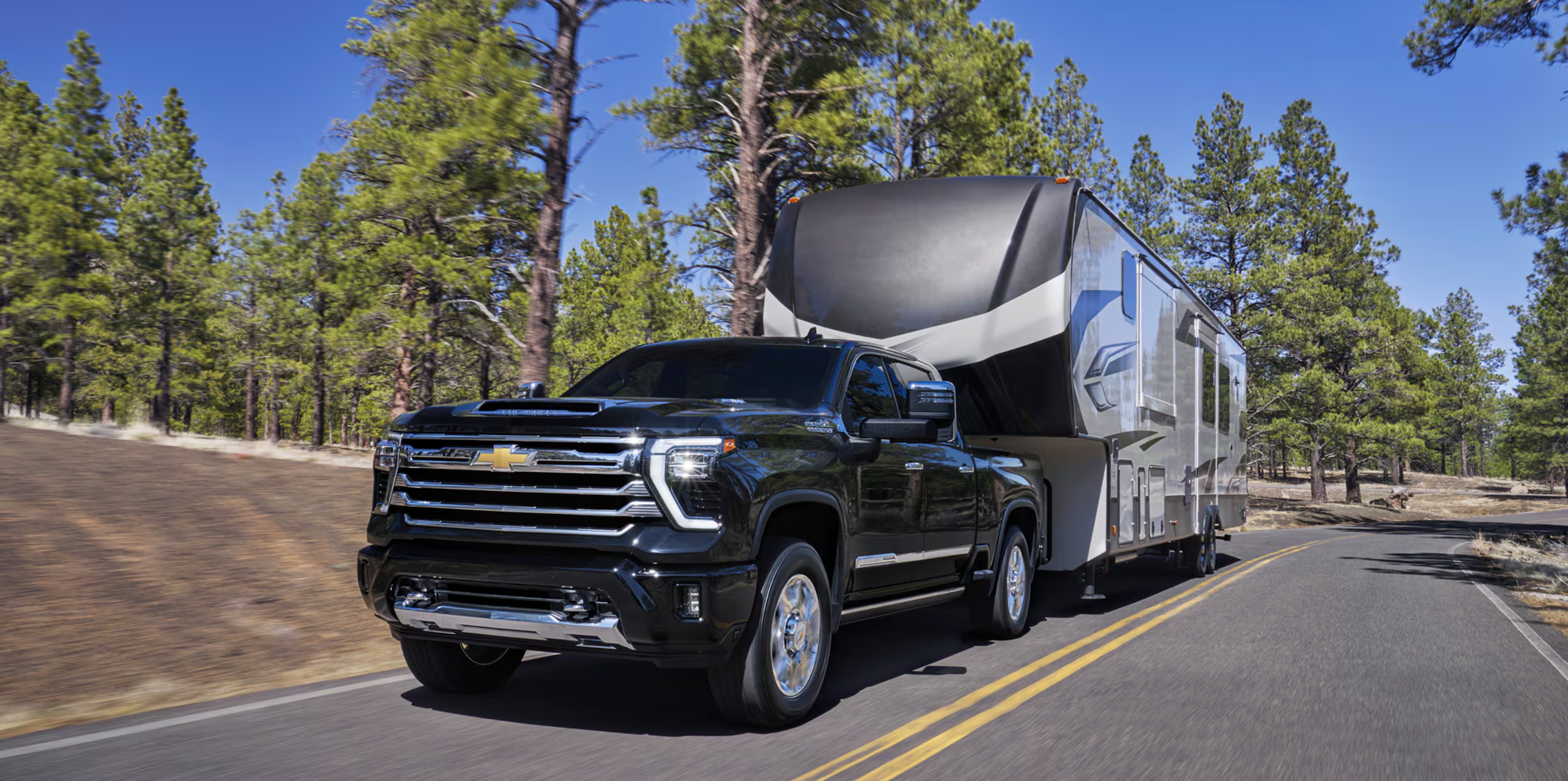 A black 2026 Chevrolet Silverado 2500 towing a trailer