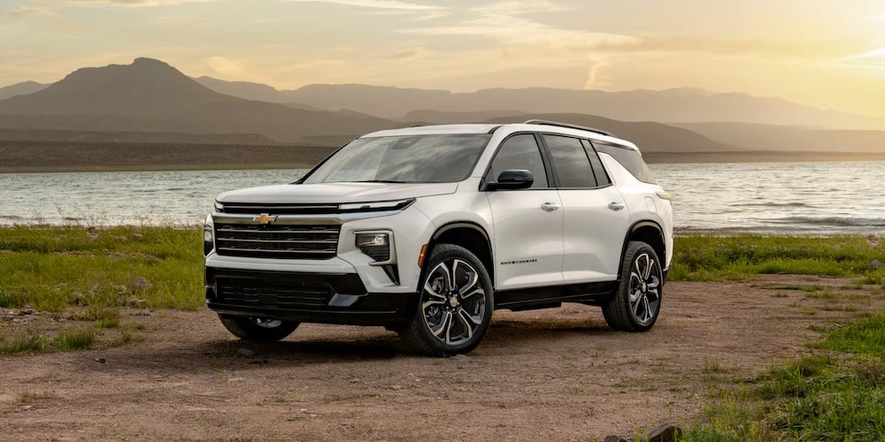 A white 2027 Chevrolet Traverse SUV parked beside a lake
