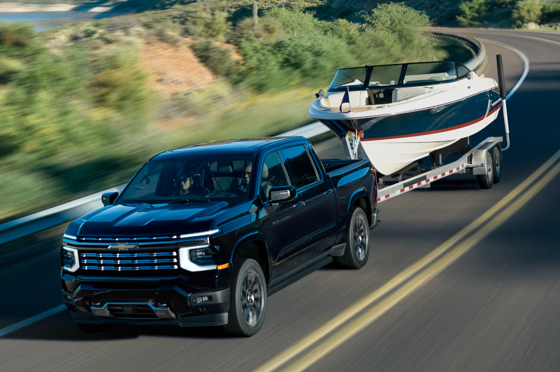 A silver 2027 Chevrolet Silverado 1500 towing a small boat